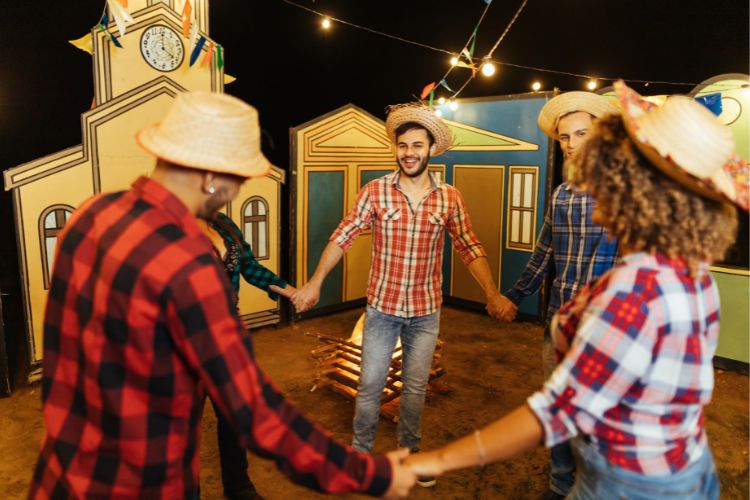 Pessoas vestidas de roupas xadrez de mãos dadas dançando