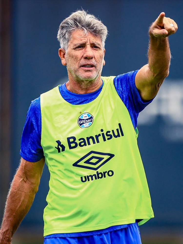 Renato Gaúcho de camisa azul e colete amarelo do Grêmio por cima