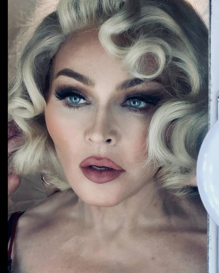 Foto do rosto de Madonna com cabelo platinado estilizado e maquiagem