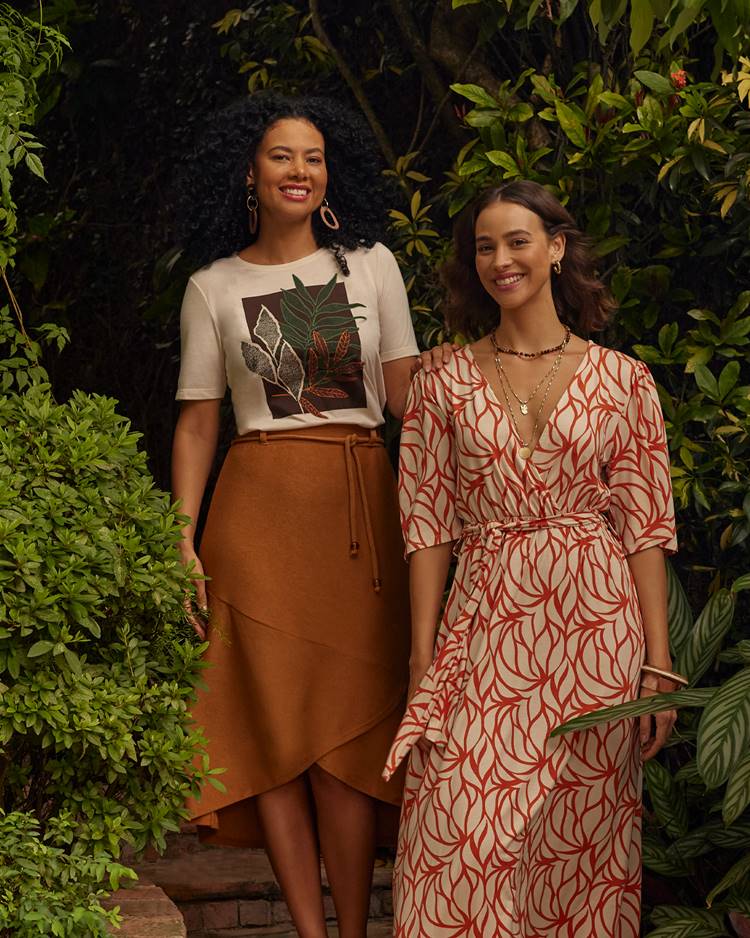 2 modelos usando roupas (vestido longo e conjunto de camiseta com saia) da nova coleção da Marisa de outono/inverno 2024 em local com plantas