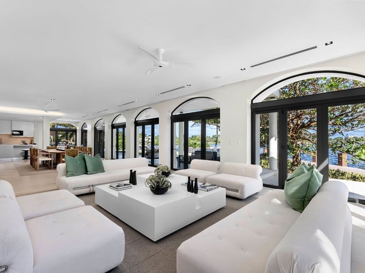 Nova mansão de Gusttavo Lima vista por dentro, sala de estar com sofás brancos e almofadas verdes