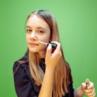 Adolescente aplicando produto no rosto