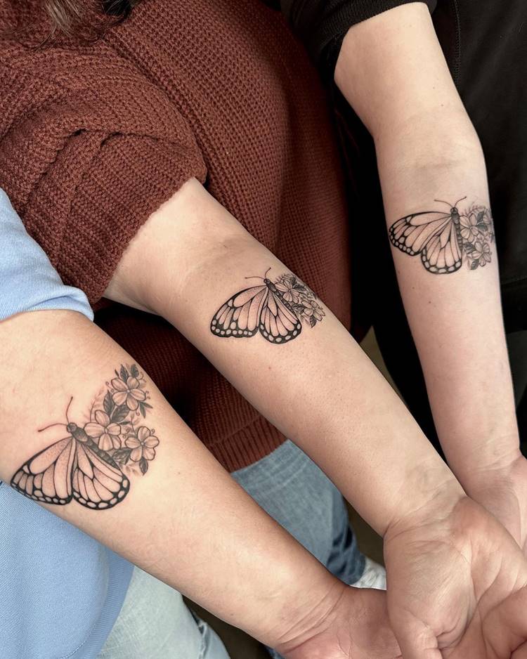Mãe e duas filhas com tatuagem de borboleta no braço