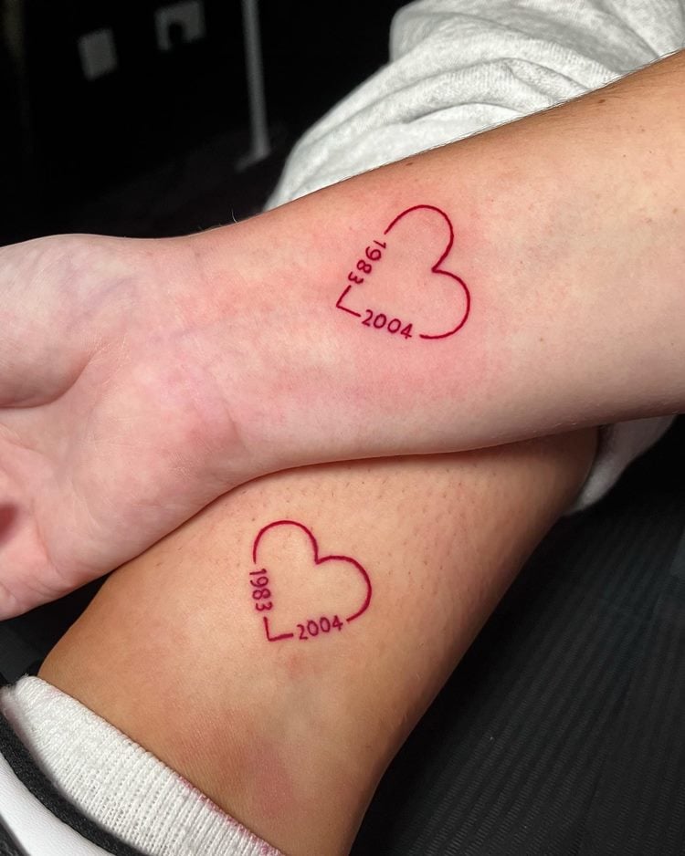 Tatuagem de coração vermelho com anos de nascimento da mãe e do filho
