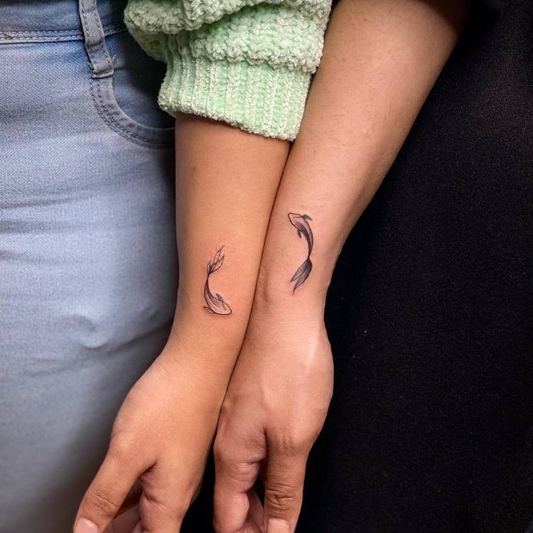 Tatuagem de peixe preto e branco em dois braços