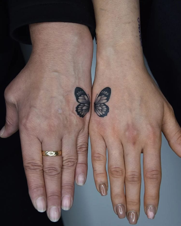 Tatuagem de mãe e filha: meia borboleta na mãe da mãe e meia na mão da ilha, cor preta
