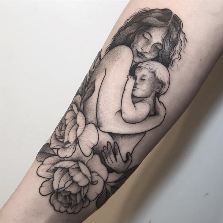Tatuagem preta de mãe abraçando o filho com flores embaixo