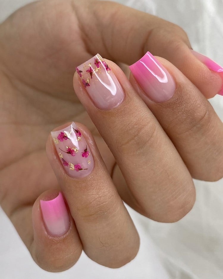 Unhas em gel cor-de-rosa (tamanho: médio. Formato: quadrada) decoradas com florzinhas na filha única e no dedo do meio