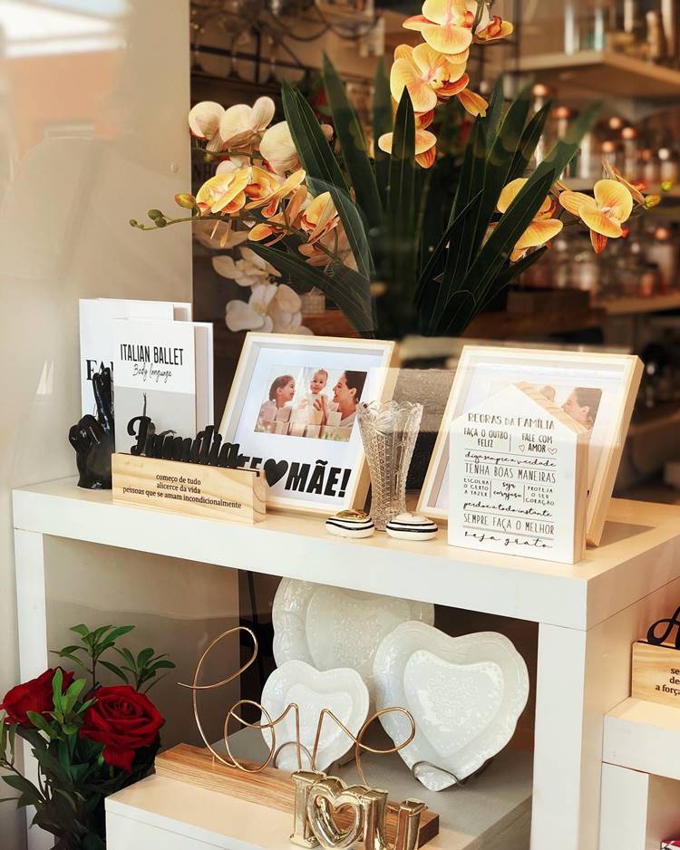 Loja decorada para o Dia da Mãe com porta-retratos, orquídeas, pratos e objetos