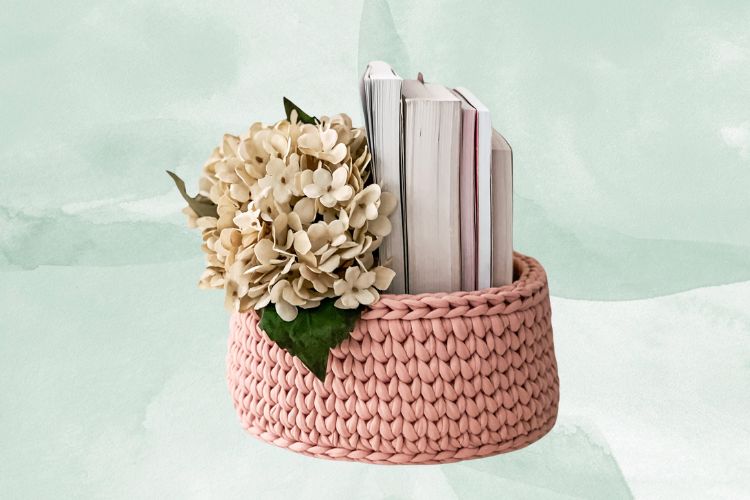 Fundo de aquarela verde com foto de cesta de crochê rosa com flores e livros