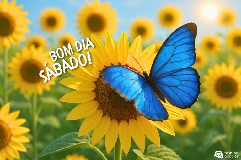 Uma borboleta azul vibrante pousa em um girassol amarelo brilhante, em um campo ensolarado de girassóis. O sol brilha no céu azul claro. A imagem tem o texto "BOM DIA SÁBADO!" em destaque, com um logotipo "fashion bubbles" no canto inferior direito.