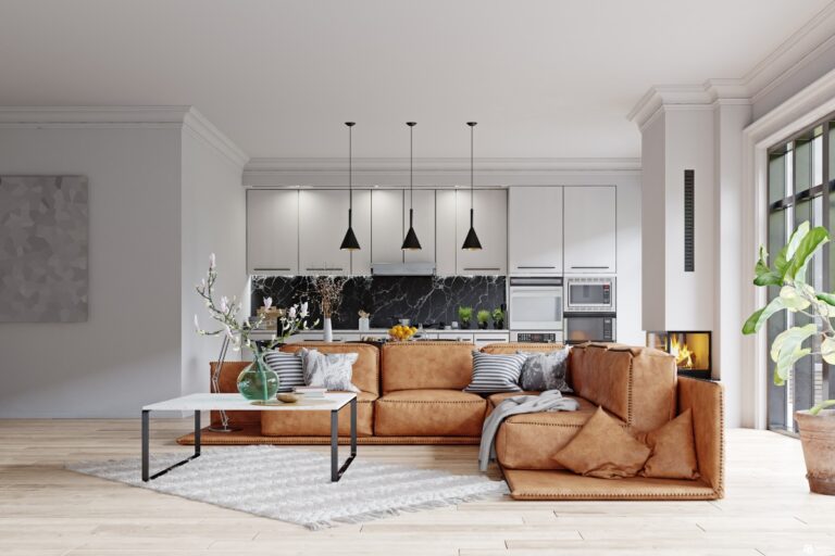 Sala com cozinha branca ao fundo, sofá marrom em couro, tapete off-white, mesa de centro branca e jardim visto pela janela