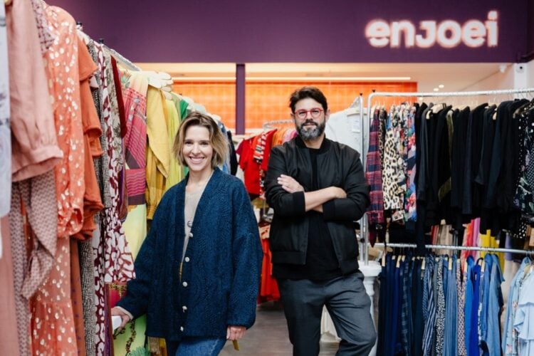 Foto da primeira loja física do brechó Enjoei, com Ana Luiza McLaren, co-fundadora, e Tiê Lima, co-fundador e CEO do Enjoei