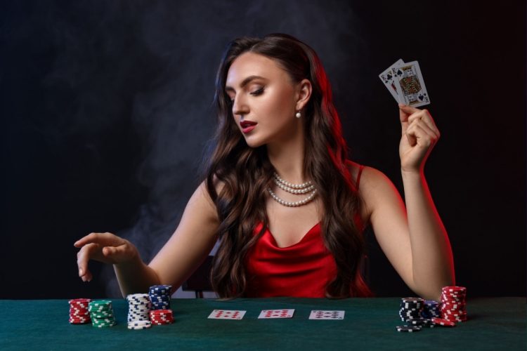 Foto de mulher com look de cassino: vestido vermelho e colar de pérolas