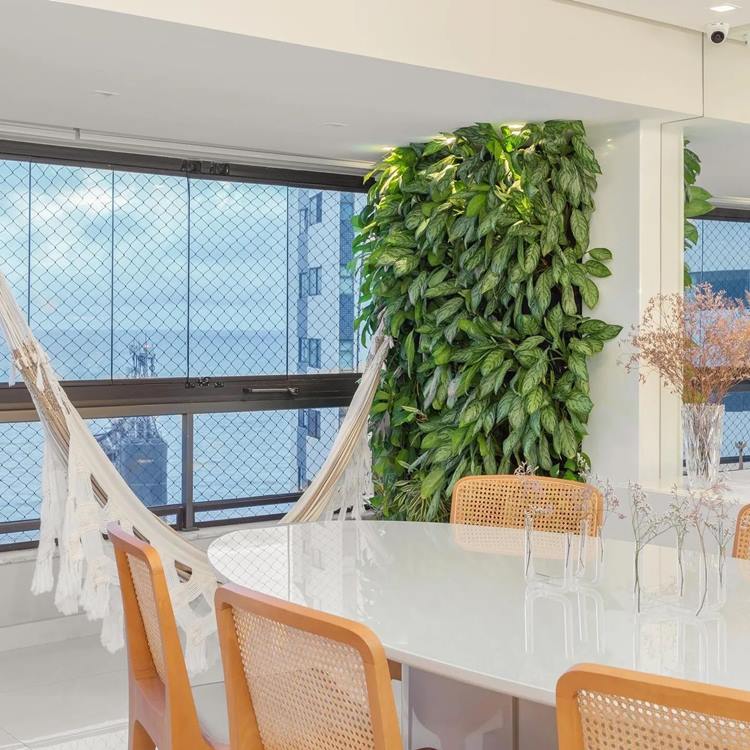 Parede verde natural em sala de jantar, com mesa e rede