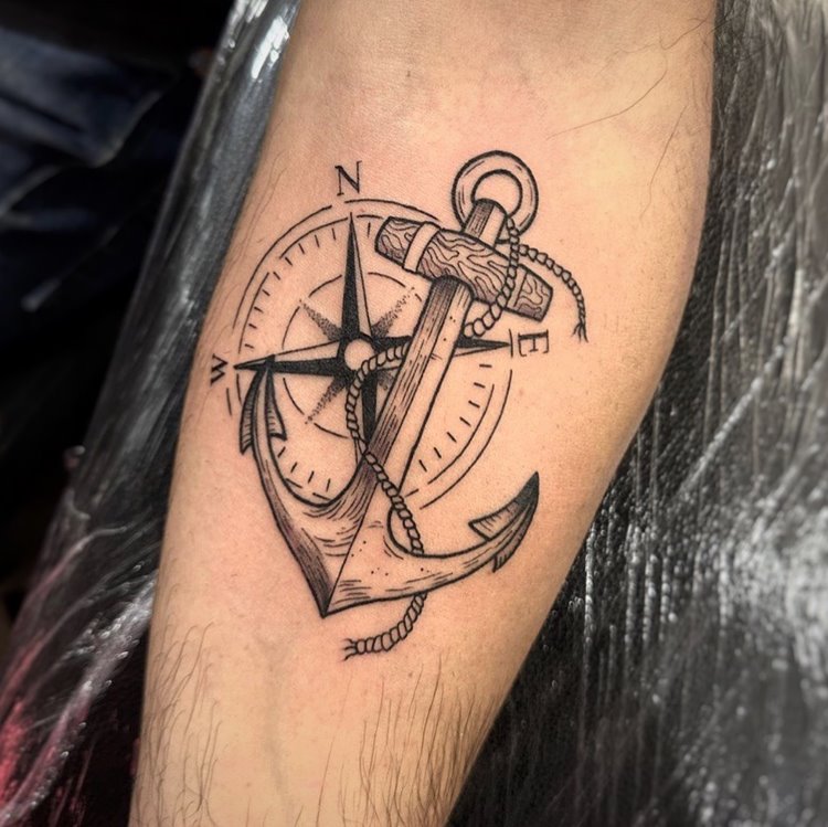 tatuagem de âncora preta com bússola  em braço