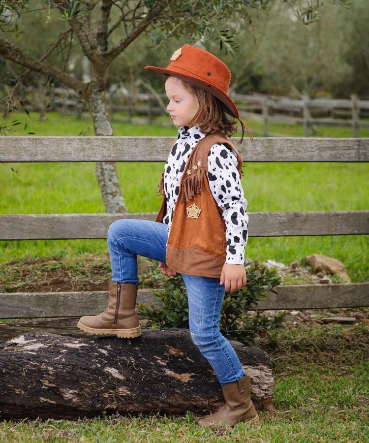 Menino com look caipira usando camisa com estampa de vaca para festa junina infantil