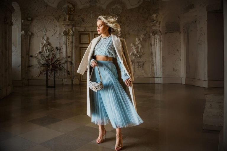 Conjunto de duas peças em azul claro, com um top de tricô cropped e uma saia midi de tule plissada. A combinação de texturas e o tom pastel criam um visual delicado e elegante, ideal para casamentos diurnos no inverno.