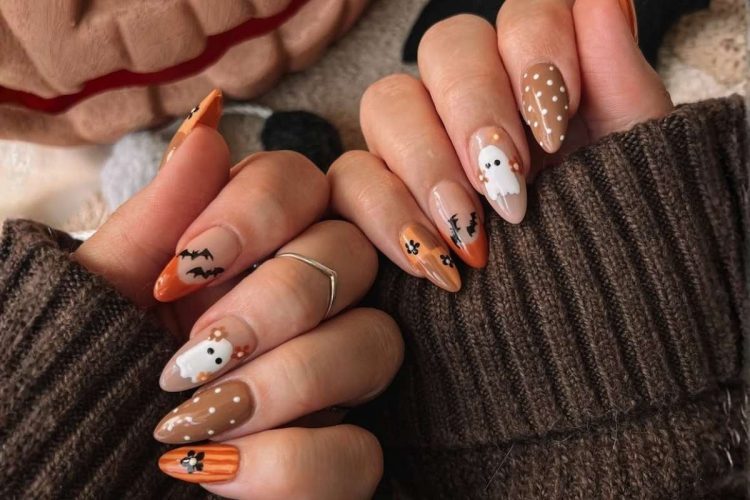 Mãos de mulher com unhas decoradas na temática Halloween