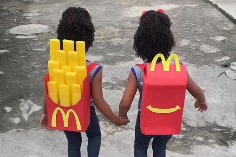 Foto de duas irmãs gêmeas com mochila maluca de McLanche Feliz e batata frita