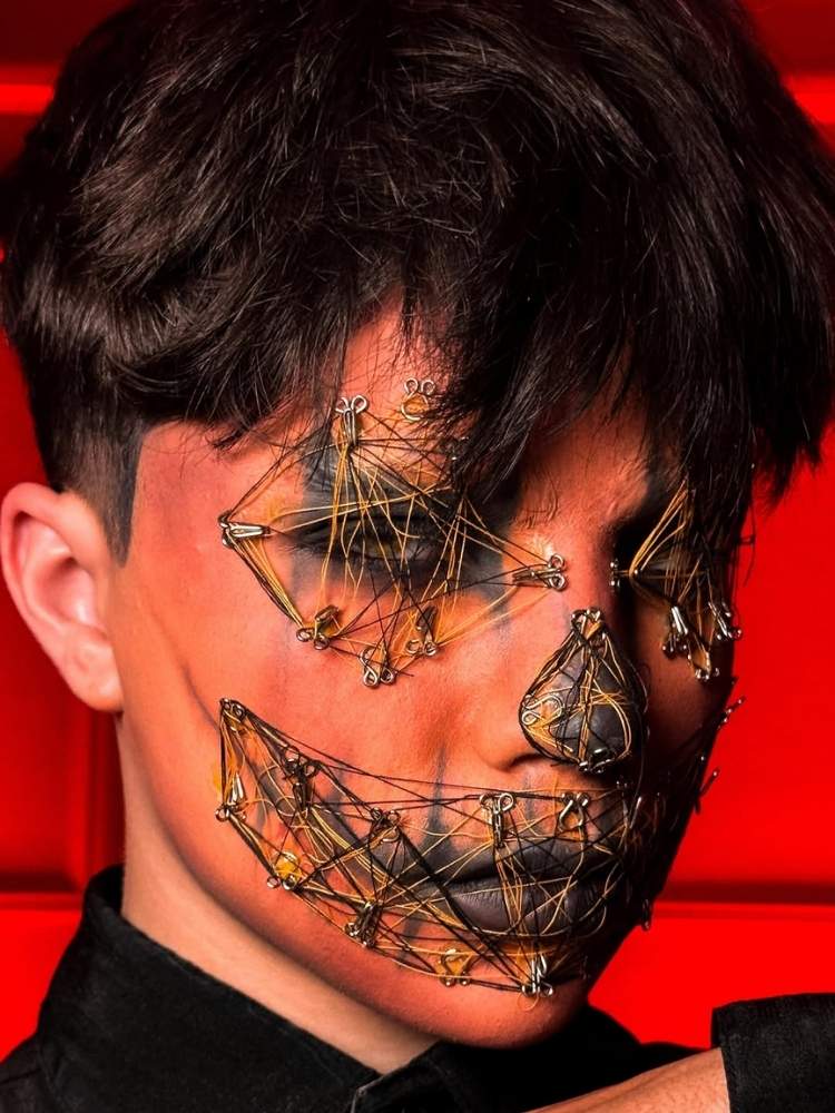 Foto de homem usando maquiagem de abóbora com olhos, nariz e boca costurados