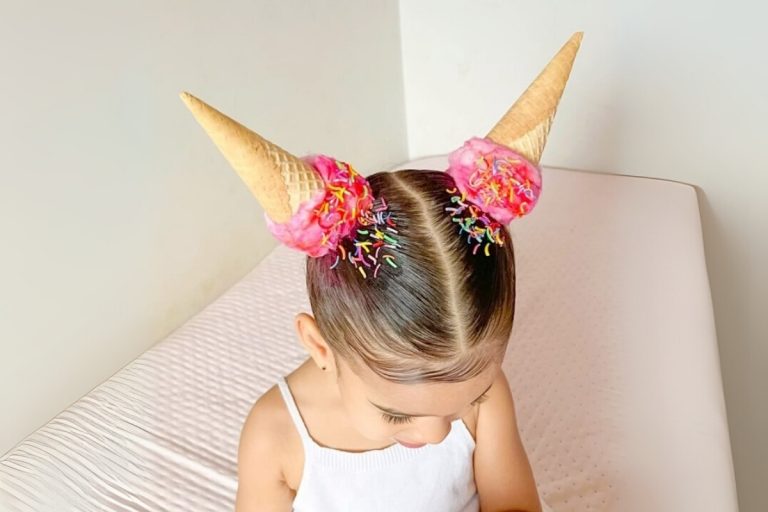 Foto de menina com cabelo maluco imitando duas casquinhas de sorvete