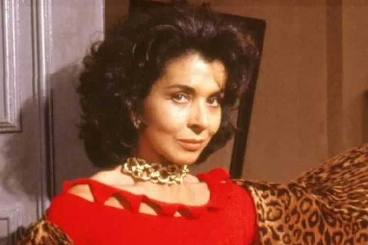 Betty Faria usando vestido vermelho e lenço de onça
