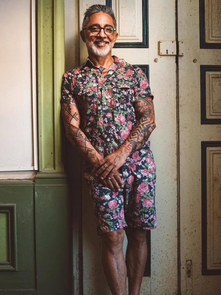 Seu Neyzinho usando camisa e bermuda estampadas coloridas