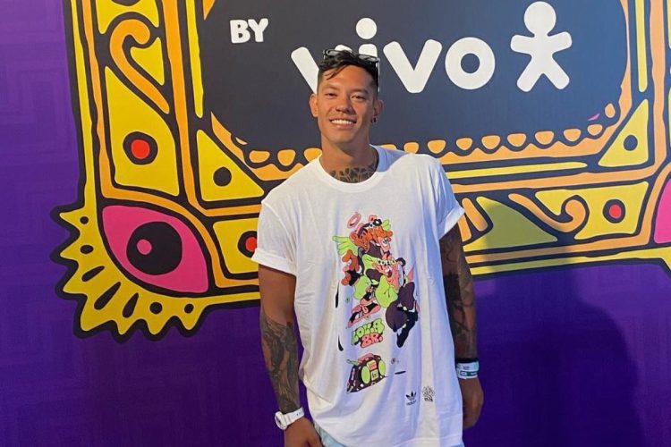 Gabriel Yoshimoto usando camiseta branca estampada em lounge do Lollapalooza