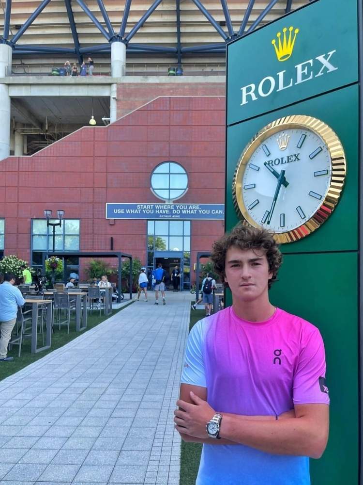 João Fonseca de blusa degradê azul e rosa em frente a Rolex