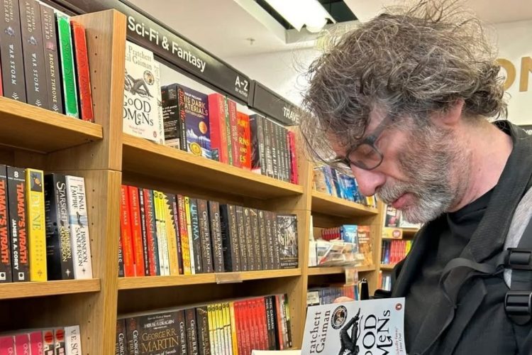 Foto de Neil Gaiman assinando livro em livraria