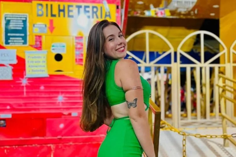 Raissa de vestido verde em frente à bilheteria do circo