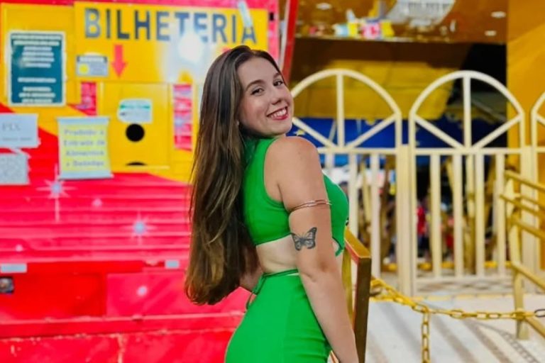 Raissa de vestido verde em frente à bilheteria do circo