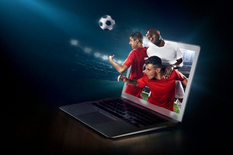 Foto de notebook com partida de futebol virtual sendo exibida