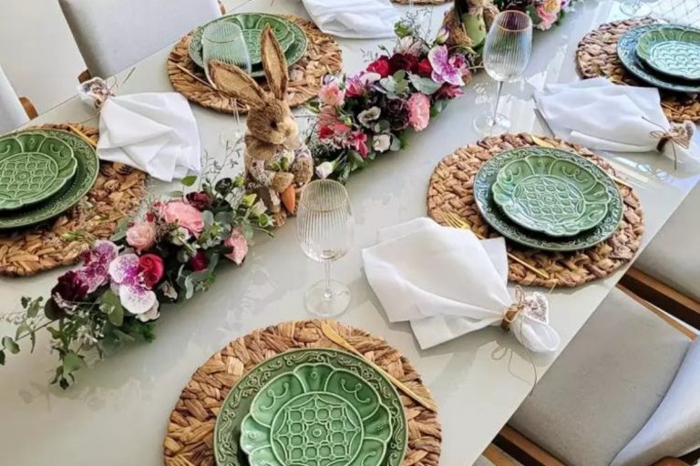 Mesa posta de Páscoa com pratos verdes e centro de mesa com coelhos