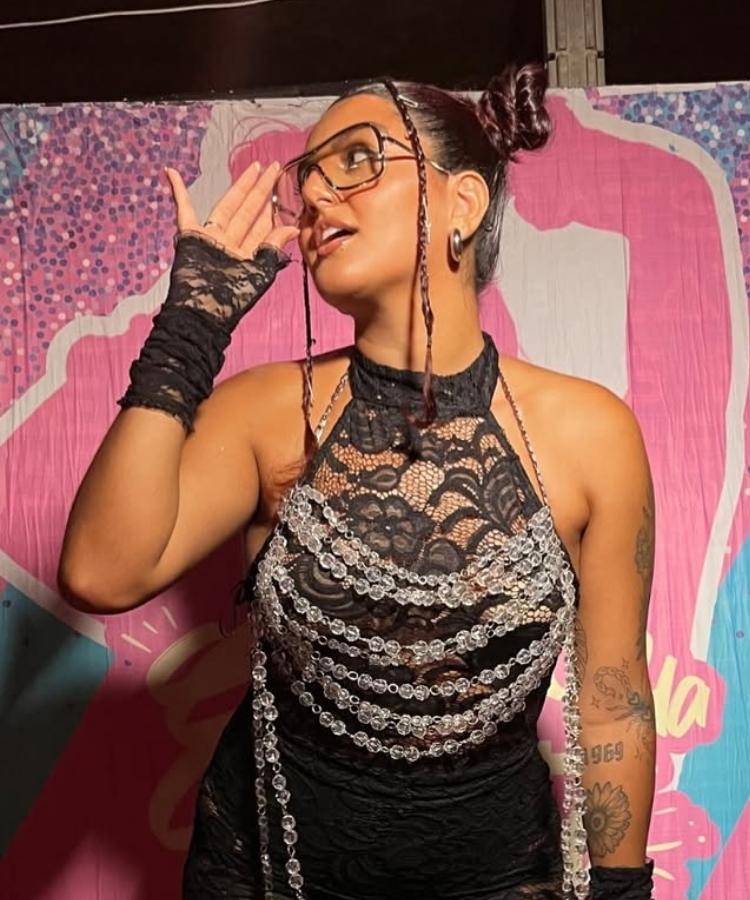Foto de influencer usando macacão de renda preto e penteado de Carnaval com trancinhas