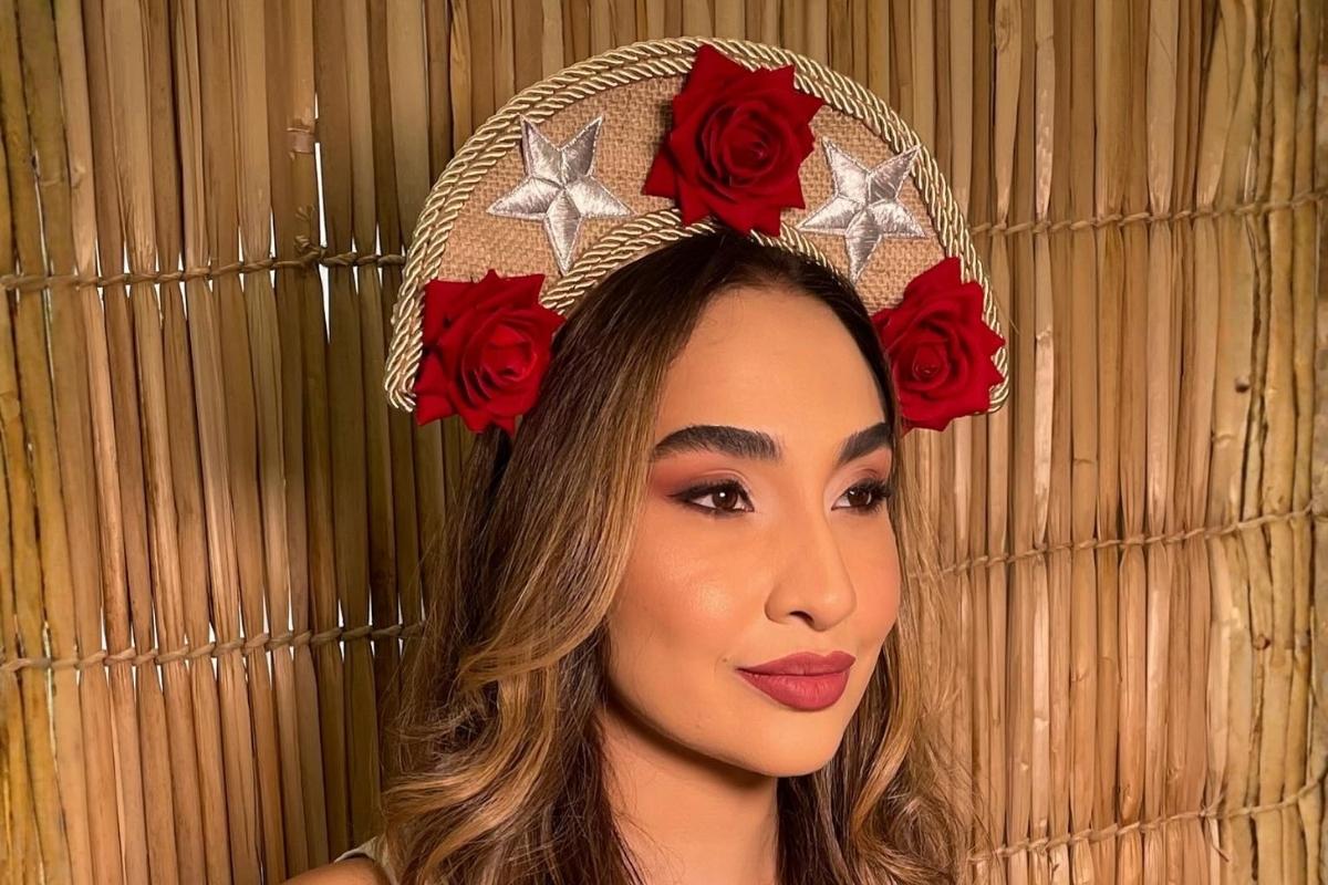Mulher usando chapéu de festa junina de cangaceiro com rosas vermelhas e estrelas prateadas
