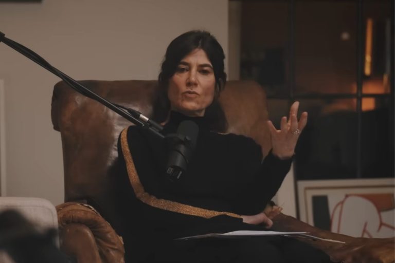 Foto de Bella Freud fazendo sessão de psicanálise, print de vídeo, Ela está sentada em uma poltrona de couro em uma sala.