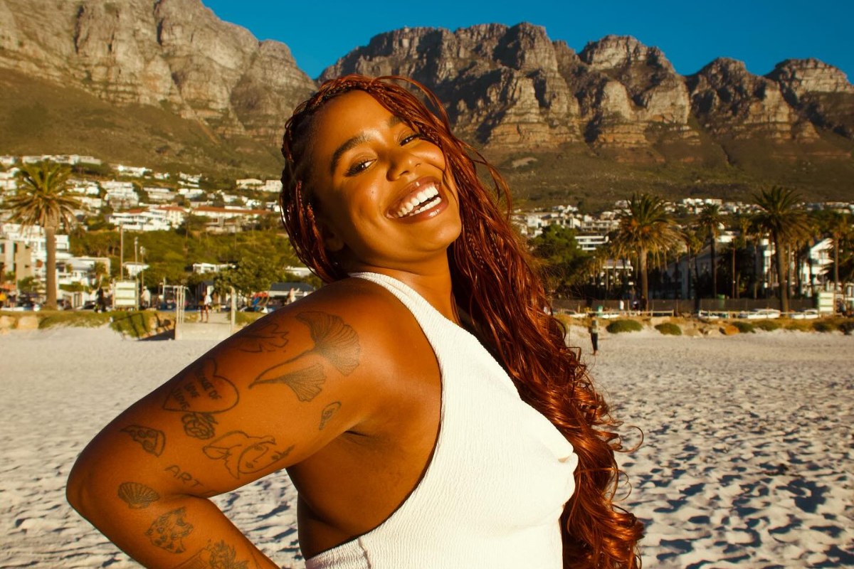 Mari Lobo de roupa branca sorrindo na praia