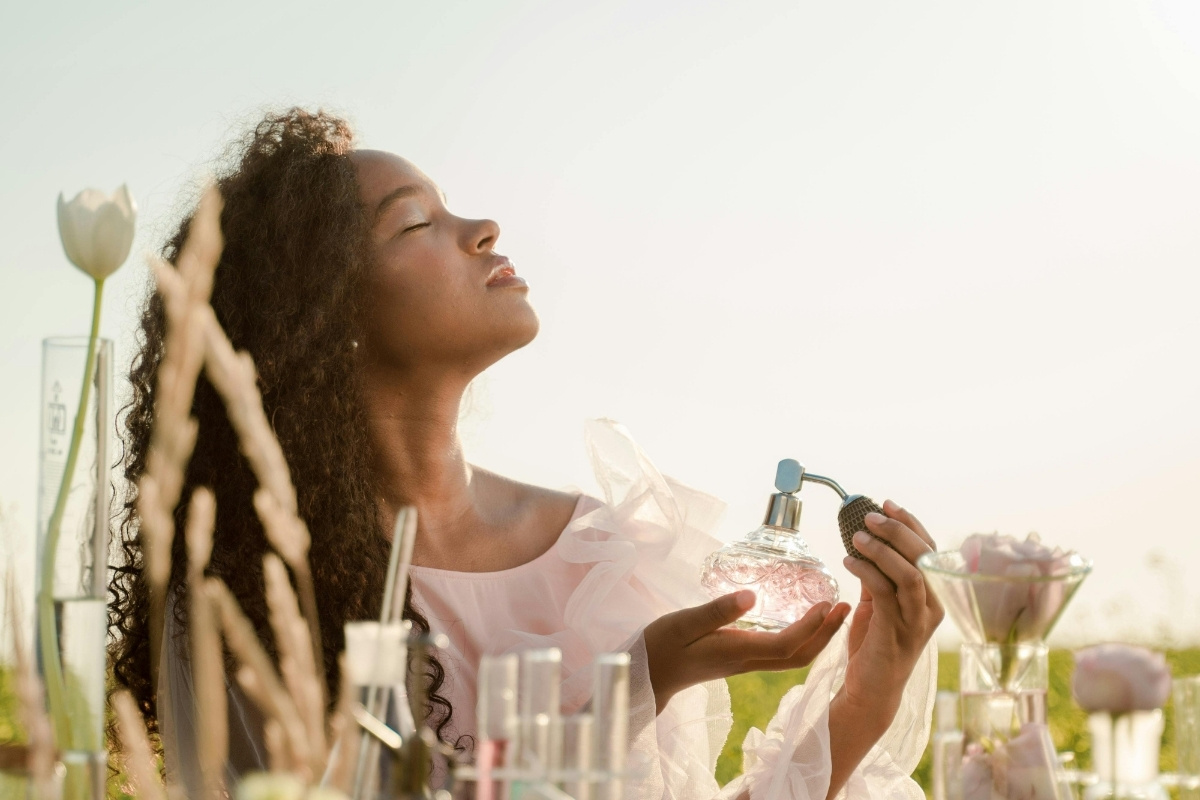 Mulher de pele negra no campo borrifando perfume