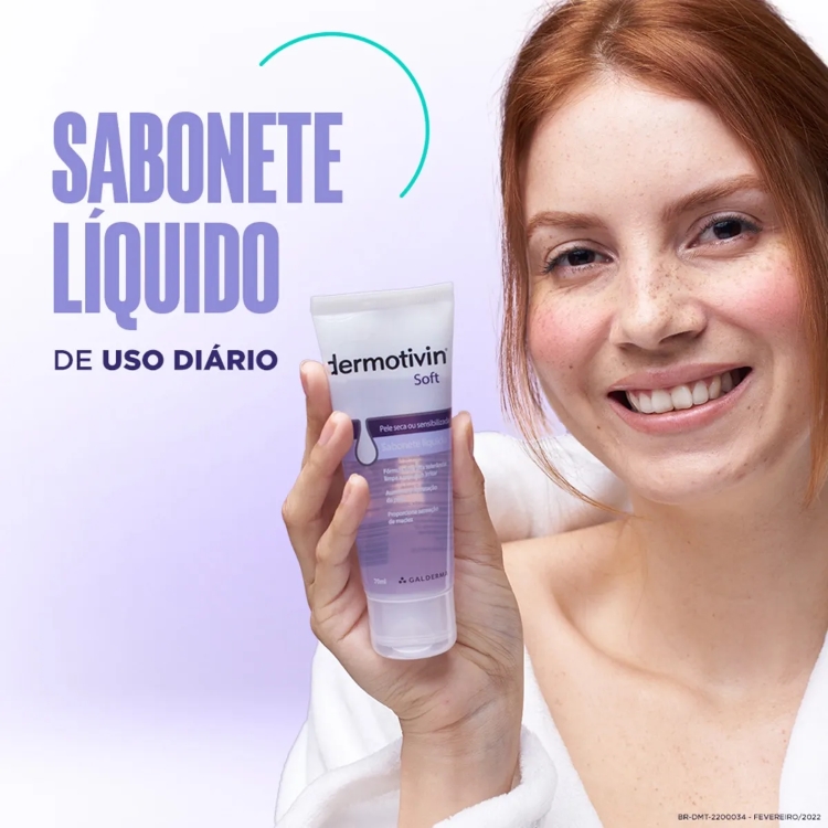A imagem mostra uma mulher ruiva sorrindo, segurando um frasco de Dermotivin Soft Sabonete Líquido. O texto "SABONETE LÍQUIDO DE USO DIÁRIO" está em destaque no lado esquerdo da imagem, com um semicírculo verde e azul adornando o topo.