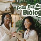 Duas mulheres em laboratório de botânica ao lado dos dizeres feliz Dia do Biólogo