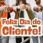 Foto de 3 mulheres com sacolas de compras e mensagem de feliz Dia do Cliente