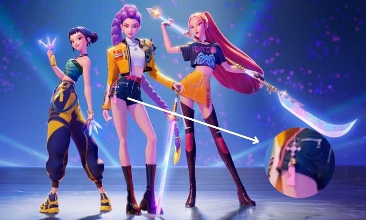 Três avatares 3D do filme "Guerreiras do K-Pop" da Netflix posam em destaque. Duas delas seguram armas. Um detalhe ampliado de um pingente de K-pop rosa na roupa de um dos avatares é visível na parte inferior direita.