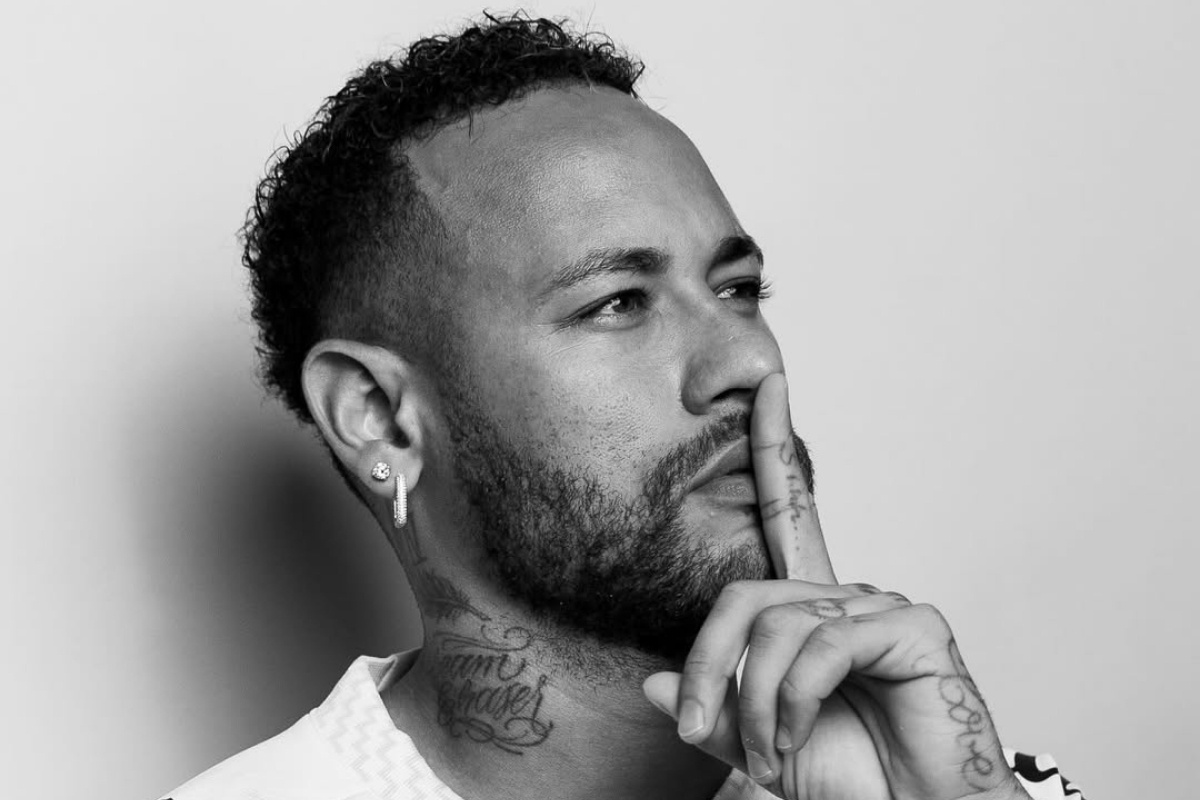 Foto em preto e branco de Neymar usando a camisa do Santos e fazendo sinal de silêncio