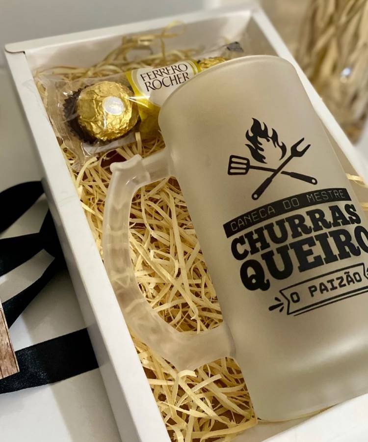 A primeira imagem exibe um presente para o Dia dos Pais: uma caneca fosca com a frase "CANECA DO MESTRE CHURRASQUEIRO O PAIZÃO" e um chocolate Ferrero Rocher, ambos cuidadosamente dispostos em uma caixa de presente com palha.