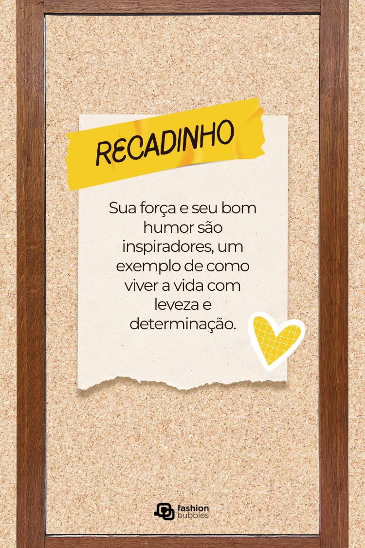 A imagem exibe um quadro de avisos com moldura de madeira, onde um "recadinho" amarelo com a palavra "RECADINHO" escrita em verde se destaca. Abaixo, um bilhete branco preso com um coração amarelo diz: "Sua força e seu bom humor são inspiradores, um exemplo de como viver a vida com leveza e determinação."