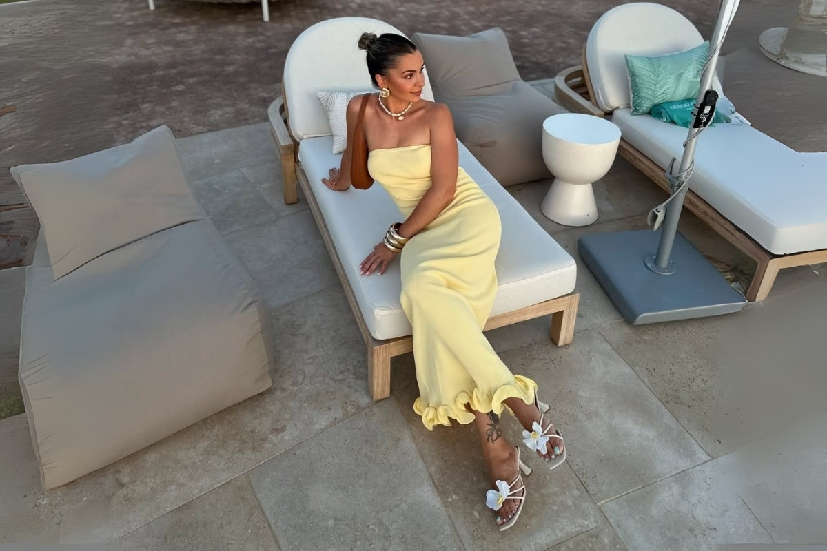 Foto de mulher usando vestido amarelo manteiga sem alças e sapato branco com aplicação de flor e salto kitten heel