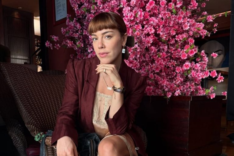 Foto de Alice Wegmann em cena usando um dos looks da Solange Duprat em Vale Tudo, vestido de cetim bege com blazer vinho