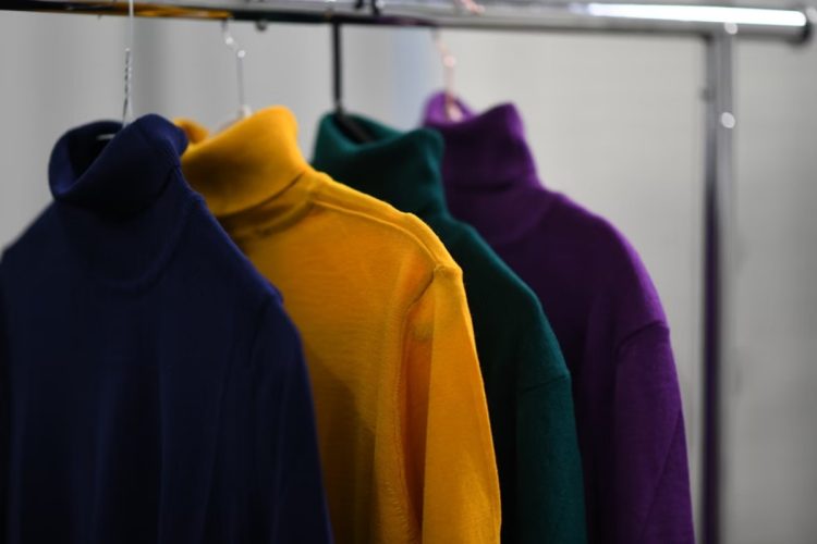Foto de blusas coloridas em cabides, com cores relacionadas a moda e superstição